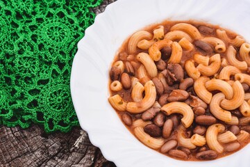 Italian style pasta fagioli dish with macaroni and kidney beans/ Pasta with beans, or pasta e fagioli, sometimes called pasta fazool/ A bowl of minestrone soup on rustic/ vintage background