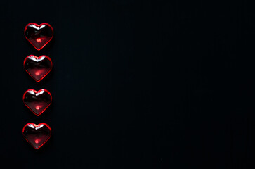 red glass hearts on a black background. unusual greeting on Valentine's Day