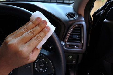 Coronavirus (COVID-19) cleaning surfaces: Car steering wheel, coronavirus cleaning in the car concept.