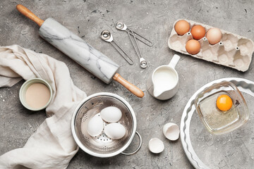Ingredients for dough and rolling pin on gray background