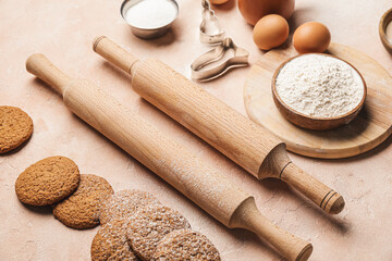 Ingredients for cookies and rolling pins on color background