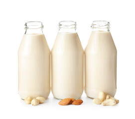 Bottles of different vegan milk on white background