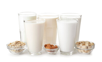 Glasses of different vegan milk on white background