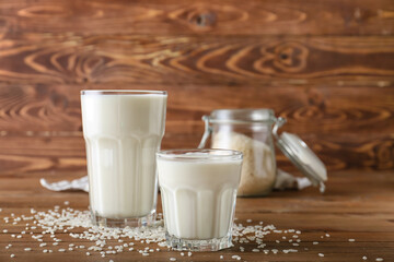 Glasses of rice milk on wooden background