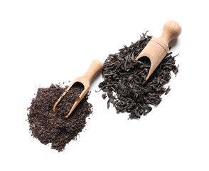 Scoops with dry black tea leaves on white background