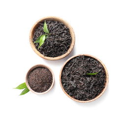 Bowls with dry black tea leaves on white background