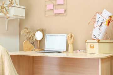 Wooden hand with laptop on table in interior of room