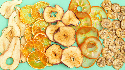 Nature Organic Dehydrated fruit chips of apple, banana, persimmon, pear, tangerine as healthy snack or sweets. Plant based food concept. Top view. Close up.