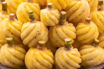 Pineapple many stacked up with fresh.