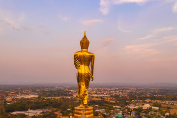 Beautiful golden buddha statue standing on a mountain Wat Phra That Khao Noi, Nan Province, Thailand.