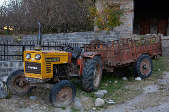 Old yellow HTM tractor with trailer, India