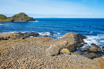 Landscape of Giant's Causeway trail with a blue sky in summer in Northern Ireland, County Antrim. UNESCO heritage. It is an area of basalt columns, the result of an ancient volcanic fissure eruption
