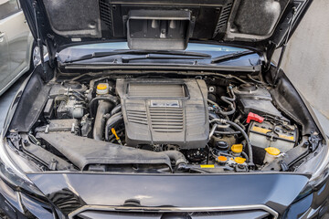 自動車のボンネットを開けた中身。誇りまみれのエンジンルーム