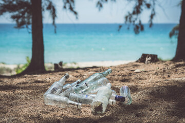 Fototapeta na wymiar Close landfill old dirty transparent discarded empty glass alcohol drinks bottles trash on ground forest nature sea park. Alcoholism addiction problem bad habits, ecology issues environment pollution