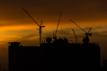 Crane and building construction site at sunset.