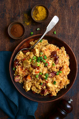 Jambalaya - spicy rice with tomatoes, meat and smoked sausage. Top view with copy space.