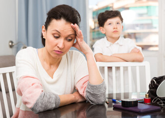 Sad and disappointed woman dont speaking with her son after discord at home