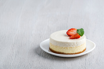 Cheesecake cake with fresh strawberries on light wooden background.