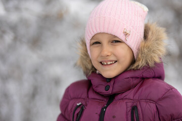 A child girl on a walk in a winter park