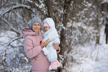 Obraz premium A woman with a baby on a walk in winter