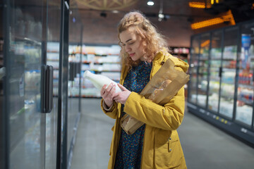 Woman in mall chooses food on the shelf