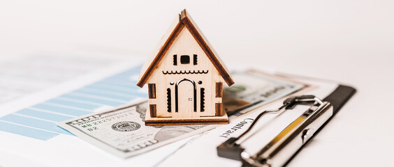 House miniature model and money on documents. Investment, real estate, home, housing