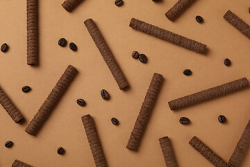 Flat lay with chocolate wafer rolls on brown background