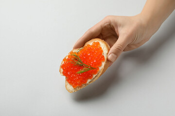 Female hand hold sandwich with caviar, isolated on white background