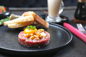 Beef tartare with yolk, pickled mushrooms and mustard. Traditional appetizer.
Serving the dish.