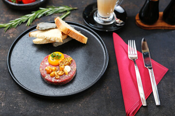 Beef tartare with yolk, pickled mushrooms and mustard. Traditional appetizer.
Serving the dish.