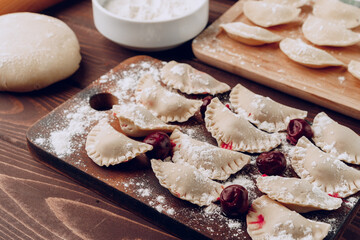 Raw stuffed russian dumplings on wooden board