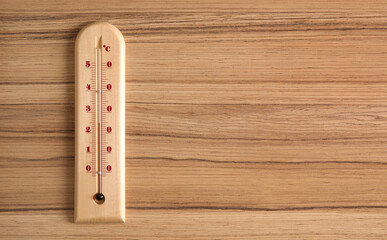 Weather thermometer on wooden table, top view. Space for text