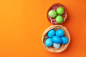 Easter eggs in a nest on orange background