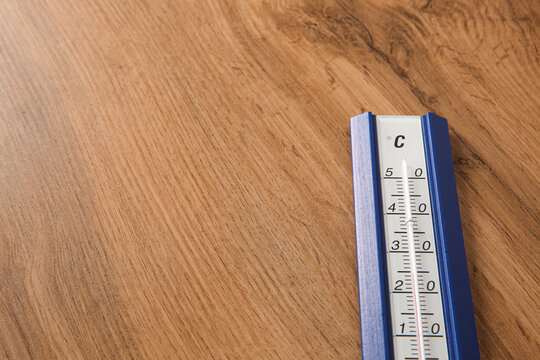 Weather thermometer on wooden table, closeup. Space for text