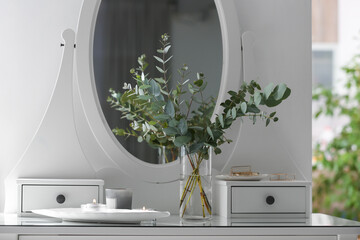 Beautiful eucalyptus branches on dressing table in room. Interior design