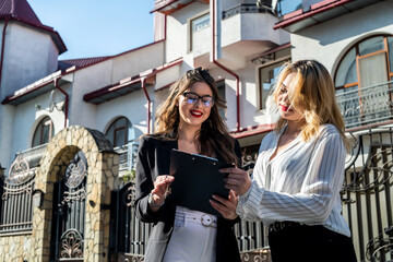 buyer and realtor signs an agreement to buy an apartment  of multi-storey building on  background
