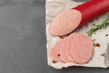 Meat sausage on parchment on gray background