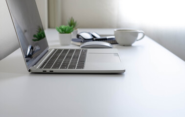 White office desk table with keyboard of laptop, coffee cup and notebook, mouse computer with equipment office supplies. Business and finance concept. Workplace, Flat lay with blank copy space.