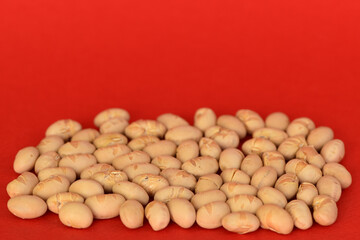 Soy beans isolated on red background.