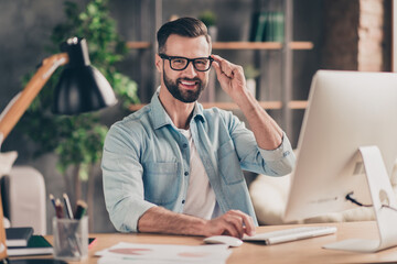 Photo portrait of guy holding glasses working on pc at table in modern industrial office indoors