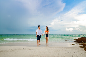 happy young couple walking on sea beach at Koh MunNork Island, Rayong, Thailand