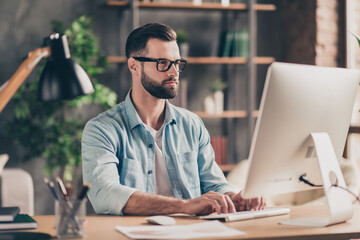 Photo portrait of man working on desktop computer at table typing indoors