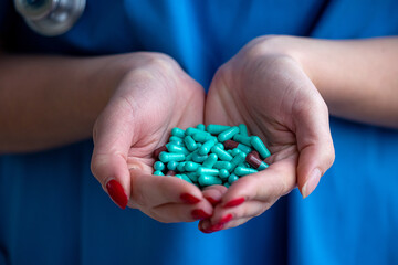 female doctor hands hold green pills