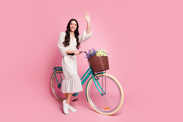 Full length body size photo of crazy female student keeping bike waving hand greeting isolated...