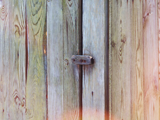 Old wooden door with swinging lock. Wooden swing gate on the door.