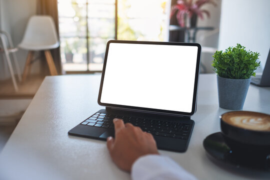 Mockup image of a business woman using and touching on tablet touchpad with blank white desktop screen as a computer pc