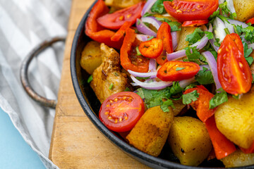 Pork ojakhuri with vegetables. Meat, potatoes, onions, herbs, peppers cooked and served in a skillet. A dish of Georgian cuisine. Meat food, lunch, dinner on the table.