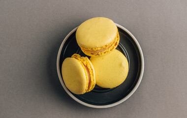 Yellow macaroons on gray background. Trend 2021 color. Top view