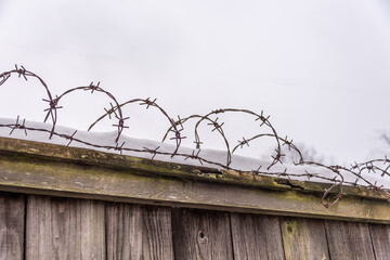 Barbed Wire on an Old Wooden Fence with Snow