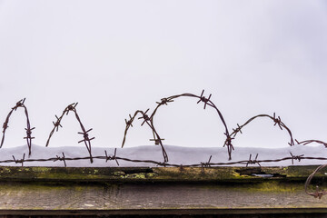 Barbed Wire on an Old Wooden Fence with Snow